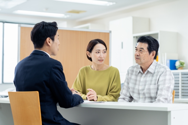 中年夫婦と話す男性スタッフ